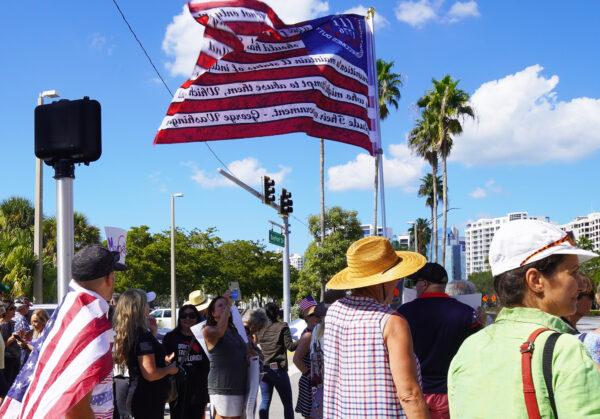 A man wields a flag at a rally against COVID-19 vaccines in Florida on Nov. 3, 2021. (Jann Falkenstern/The Epoch Times)