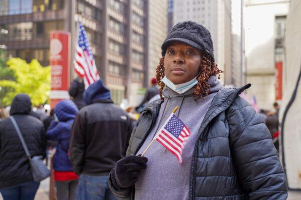 Lynette Taylor holds an American flag at a protest against the city's vaccine mandate at a rally outside the James R. Thompson Center in downtown Chicago on Nov 3, 2021. (Cara Ding/The Epoch Times)