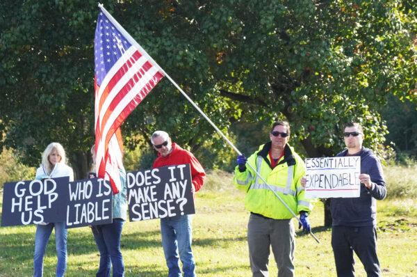 Jeff Langstrom holds a flag at a vaccine protest in Marietta, Ga., on Nov. 3, 2021. (Jackson Elliott/The Epoch Times)