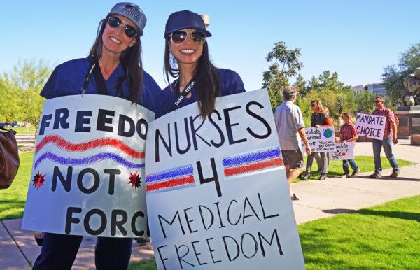 Registered nurses Carrie Cullen (L) and Rachel Wallace protest in support of medical freedom at a rally held in Phoenix on Nov. 3, 2021. (Allan Stein/The Epoch Times)