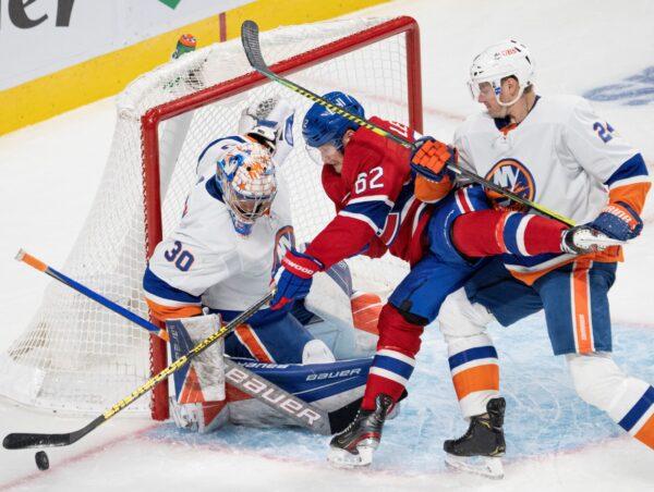 Montreal Canadiens' Artturi Lehkonen (62) is sandwiched between New York Islanders goaltender Ilya Sorokin (30) and Islanders' Scott Mayfield (24) during the third period of an NHL hockey game in Montreal, Canada, on Nov. 4, 2021. (Ryan Remiorz/The Canadian Press via AP)