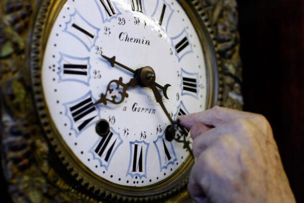Howie Brown adjusts the time on a clock back one hour for the end of daylight savings time at Brown's Old Time Clock Shop in Plantation, Fla., on Nov. 2, 2007. (Joe Raedle/Getty Images)