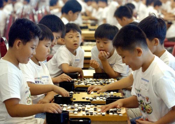 South Korean students place white and black stones during the World Elementary School Student Go Game, the ancient Chinese board game, competition in Seoul, on July 29 2005. (JUNG YEON-JE/AFP via Getty Images)