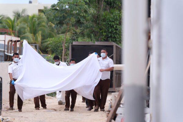 Police hold a bed sheet in an attempt to block onlookers after an armed confrontation close to a hotel near Puerto Morelos, Mexico, on Nov. 4, 2021. (Karim Torres/AP Photo)