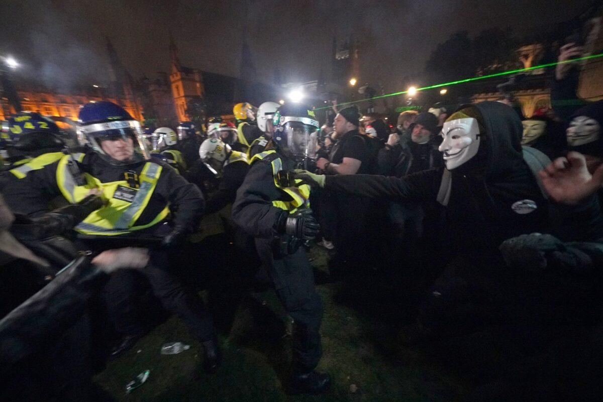 Police clash with protesters as they take part in the Million Mask March in Parliament Square, London, on Nov. 5, 2021. (PA)