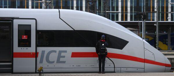 An employee of German railway operator Deutsche Bahn (DB) stands next to an ICE high-speed train at the main railway station in Munich, southern Germany, on Aug. 23, 2021. (Christof Stache/AFP via Getty Images)