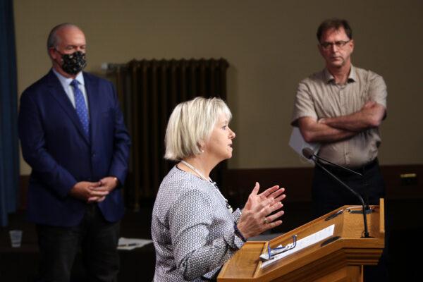 B.C. Premier John Horgan and Health Minister Adrian Dix look on as Provincial Health Officer Dr. Bonnie Henry speaks at a press conference in Victoria, on Aug. 23, 2021. (The Canadian Press/Chad Hipolito)