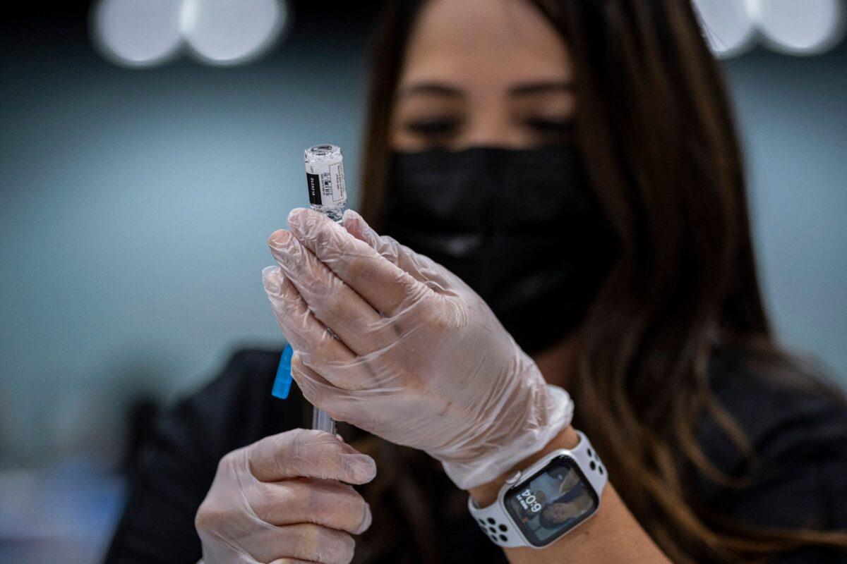 A health worker prepares a dose of the Johnson & Johnson COVID-19 vaccine at the Puerto Rico Convention Center during the first mass vaccination event in San Juan, Puerto Rico, on March 31, 2021. (Ricardo Arduengo/AFP via Getty Images)