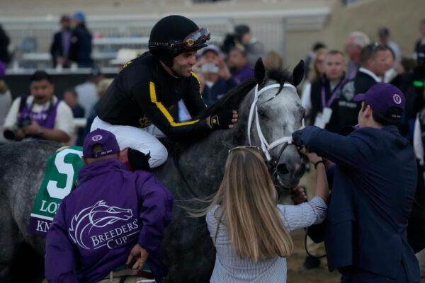 Joel Rosario, top, celebrates after riding Knicks Go to victory during the Breeders' Cup Classic race at the Del Mar racetrack in Del Mar, Calif., on Nov. 6, 2021. (Gregory Bull/AP Photo)