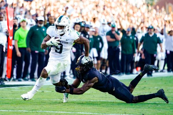 Michigan State running back Kenneth Walker III (9) breaks the tackle of Purdue cornerback Jamari Brown (7) on his way to a touchdown during the first half of an NCAA college football game in West Lafayette, Ind., on Nov. 6, 2021. (Michael Conroy/AP Photo)
