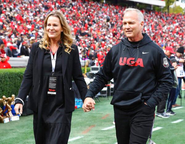 Former Georgia head coach Mark Richt holds his wife Katharyn's hand on the sideline during an NCAA college football game against Missouri in Athens, Ga., on Nov. 6, 2021. (Curtis Compton/Atlanta Journal-Constitution via AP)