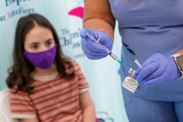 An 11-year-old girl watches as a nurse prepares a syringe with a dose of Pfizer's COVID-19 vaccine, at The Children's Hospital at Montefiore in New York City on Nov. 3, 2021. (Mary Altaffer/AP Photo)