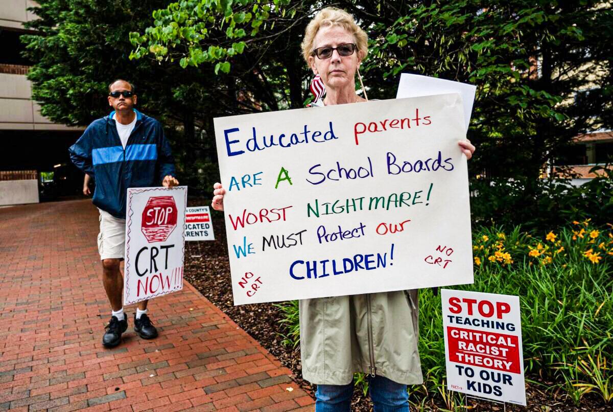 People hold up signs during a rally against "critical race theory" (CRT) being taught in schools at the Loudoun County Government center in Leesburg, Va., on June 12, 2021. (Andrew Caballero-Reynolds/AFP via Getty Images)