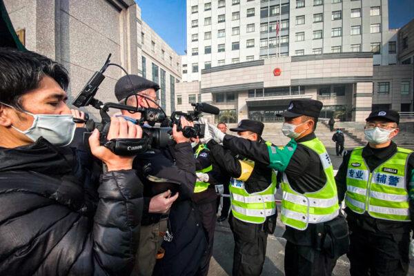 Police attempt to stop journalists from recording footage outside the Shanghai Pudong New District People's Court, where citizen journalist Zhang Zhan was sentenced, in Shanghai, on Dec. 28, 2020. (Leo Ramirez/AFP via Getty Images)