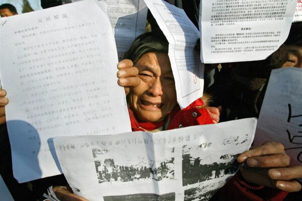 A petitioner shows documents during a gathering to protest against corruption and graft ahead of the nation's annual "legal day," in Beijing, on Dec. 3, 2007. (Teh Eng Koon/AFP via Getty Images)