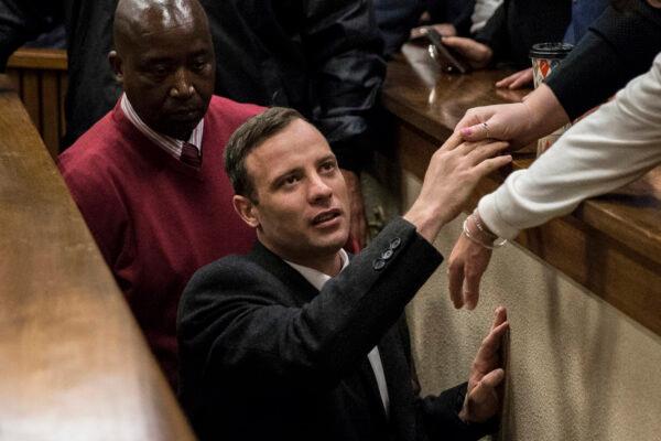 Olympic athlete Oscar Pistorius holds the hand of a relative after sentencing at the High Court, South Africa, on July 6, 2016. (Marco Longari/Pool/Getty Images)