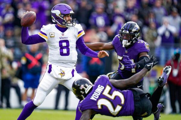Minnesota Vikings quarterback Kirk Cousins (8) throws under pressure from Baltimore Ravens cornerback Tavon Young (25) and outside linebacker Tyus Bowser (54) during the second half of an NFL football game in Baltimore, on Nov. 7, 2021. (Julio Cortez/AP Photo)