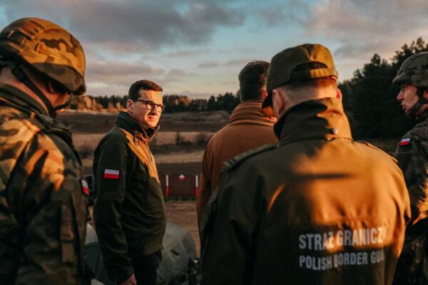 Poland's Prime Minister Mateusz Morawiecki and Minister of National Defence Mariusz Blaszczak meet with service members near the frontier, as hundreds of migrants gather on the Belarusian side of the border with Poland in an attempt to cross it, on Nov. 9, 2021. (Polish Prime Minister's Office)
