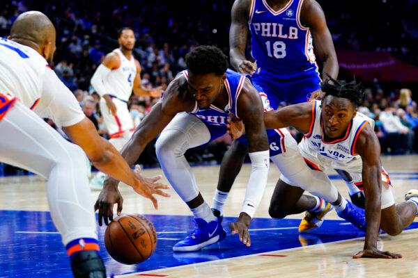 Philadelphia 76ers' Paul Reed, center, Immanuel Quickley, right, and Taj Gibson lunge for a loose ball during the first half of an NBA basketball game in Philadelphia, on Nov. 8, 2021. (Matt Slocum/AP Photo)