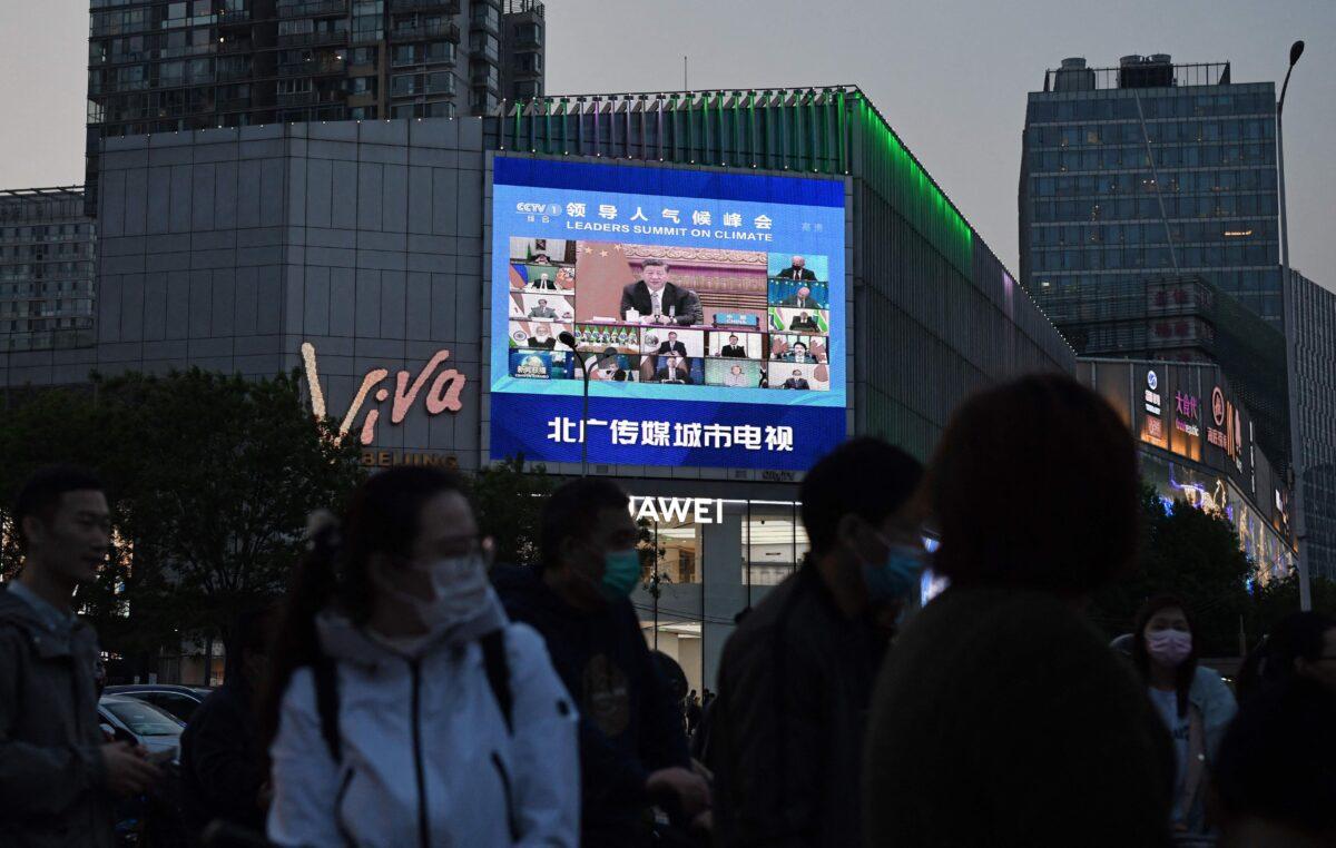 A news program report on CCP leader Xi Jinping's appearance at a U.S.-led climate summit is seen on a giant screen in Beijing on April 23, 2021. (Greg Baker/AFP via Getty Images)