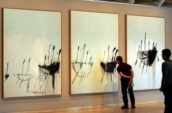 Visitors take a close look at an abstract triptych entitled “Three studies from the Temeraire” by U.S. artist Cy Twomby at the Art Gallery of New South Wales in Sydney, Australia, on Nov. 16, 2004. (Greg Wood/AFP via Getty Images)