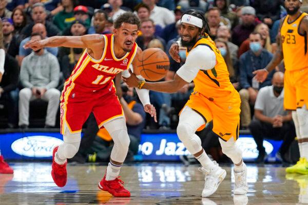 Atlanta Hawks guard Trae Young (11) battles for a loose ball with Utah Jazz guard Mike Conley (11) in the first half during an NBA basketball game in Salt Lake City, on Nov. 9, 2021. (Rick Bowmer/AP Photo)