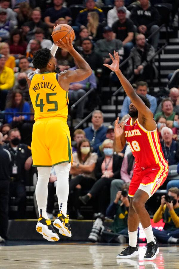 Utah Jazz guard Donovan Mitchell (45) shoots as Atlanta Hawks forward Solomon Hill (18) defends during the first half of an NBA basketball game in Salt Lake City, on Nov. 9, 2021. (Rick Bowmer/AP Photo)