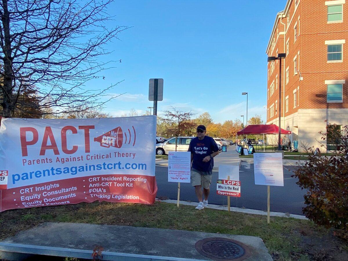 Scott Mineo, founder of local advocacy group Parents Against Critical Theory, sets up anti-CRT signs outside the Loudoun County Public Schools administration building ahead of a school board meeting in Ashburn, Va., on Nov. 9, 2021. (Terri Wu/The Epoch Times)
