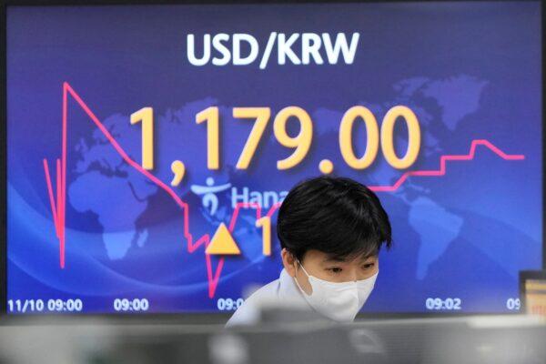 A currency trader watches computer monitors near a screen showing the foreign exchange rate between the U.S. dollar and South Korean won at a foreign exchange dealing room in Seoul, South Korea on Nov. 10, 2021. (Lee Jin-man/AP Photo)