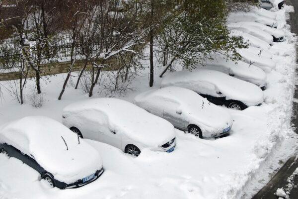 In this photo released by Xinhua News Agency, snow covered cars are seen at a park in Shenyang, northeast China's Liaoning Province, Nov. 9, 2021. (Yang Qing/Xinhua via AP)