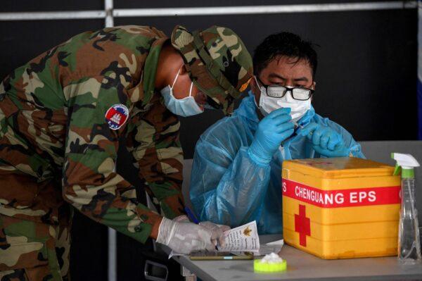 A military medical worker prepares a dose of China's Sinovac COVID-19 vaccine at the Australian Centre for Education in Phnom Penh, Cambodia, on May 1, 2021. (Tang Chhin Sothy/AFP via Getty Images)