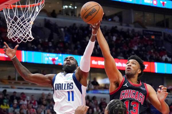 Dallas Mavericks forward Tim Hardaway Jr., left, and Chicago Bulls center Tony Bradley reach for a rebound during the first half of an NBA basketball game in Chicago, on Nov. 10, 2021. (Nam Y. Huh/AP Photo)