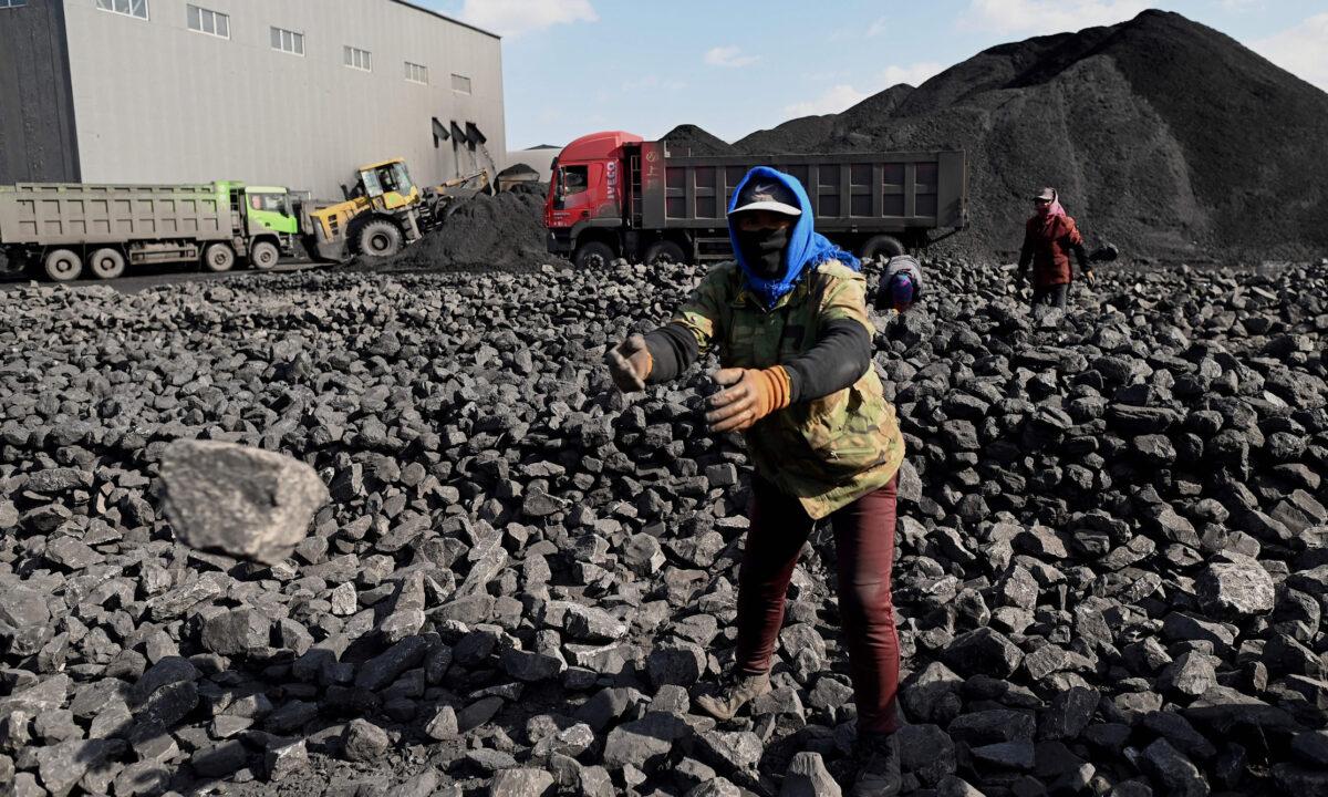 Workers sort coal near a coal mine in Datong, China's northern Shanxi province on November 3, 2021. (Noel Celis/AFP via Getty Images)