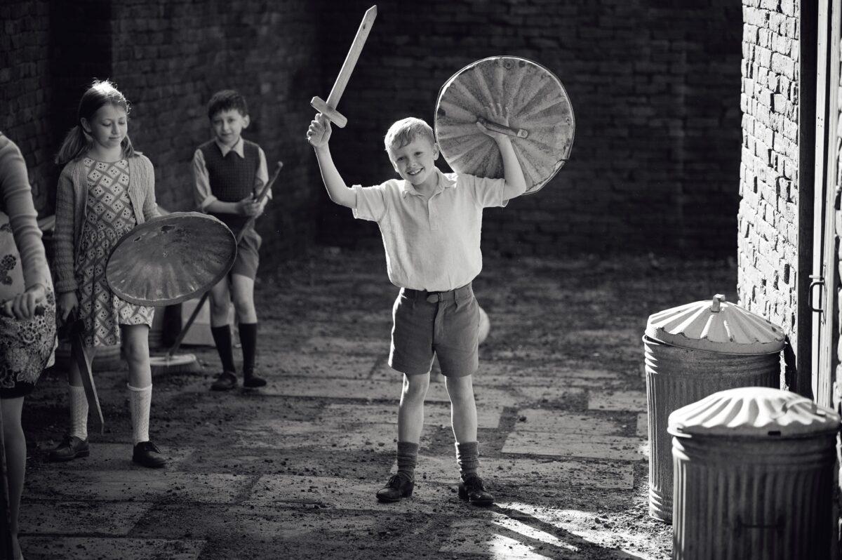 Buddy (Jude Hill) and his friends play knights in the streets of Belfast, in “Belfast.” (Rob Youngson/Focus Features)