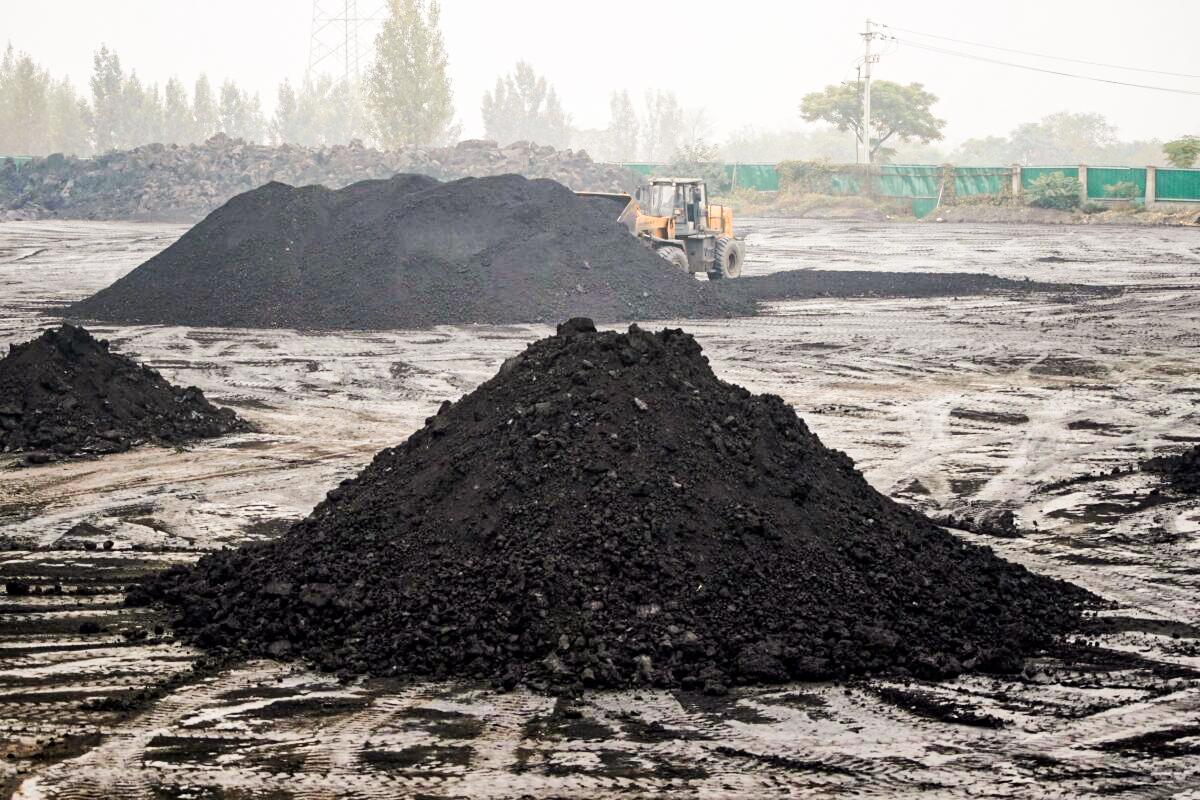 An excavator sift through dunes of low-grade coal near a coal mine in Pingdingshan, Henan Province, China, on Nov. 5, 2021. (Aly Song/Reuters)