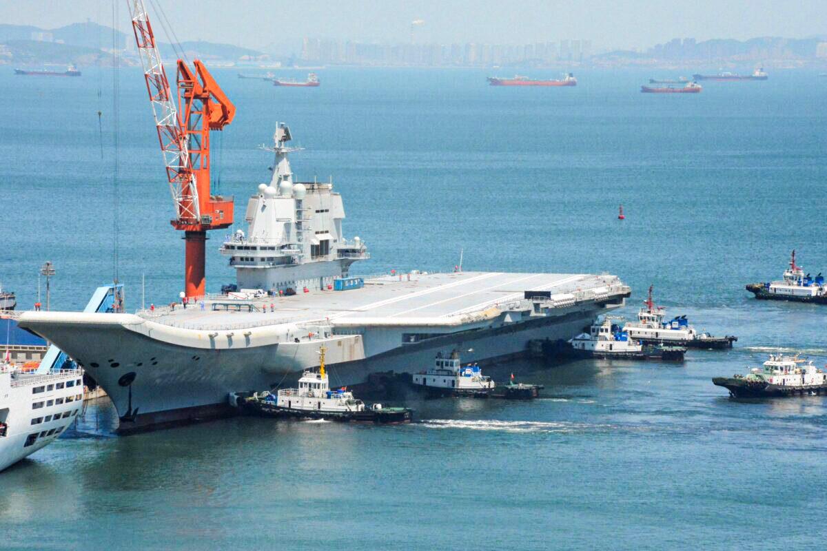 This photo taken on May 18, 2018 shows tugs guiding China's first domestically manufactured aircraft carrier, known as "Type 001A", as it returns to port in Dalian in China's northeastern Liaoning province after its first sea trial. (AFP via Getty Images)