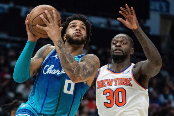 Charlotte Hornets forward Miles Bridges (0) drives to the basket while guarded by New York Knicks forward Julius Randle (30) during the first half of an NBA basketball game in Charlotte, N.C., on Nov. 12, 2021. (Jacob Kupferman/AP Photo)