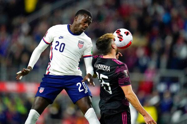United States' Tim Weah (L) goes up for the ball against Mexico's Hector Herrera during the first half of a FIFA World Cup qualifying soccer match, in Cincinnati, on Nov. 12, 2021. (Julio Cortez/AP Photo)