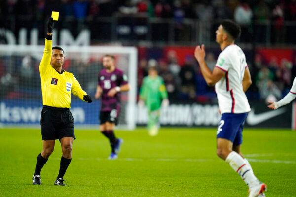 Referee Ivan Barton (L) gives a yellow card to United States' Miles Robinson (R) during the second half of a FIFA World Cup qualifying soccer match against Mexico, in Cincinnati, on Nov. 12, 2021. (Julio Cortez/AP Photo)