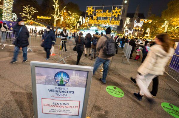 A sign warns visitors about controls of their status—vaccinated or healed from COVID-19—at the entrance to the "Christkindlmarkt," Vienna's classic Christmas Market, on the square in front of the City Hall in Vienna, Austria, on Nov. 12, 2021 (Georg Hockmuth/APA/AFP via Getty Images)
