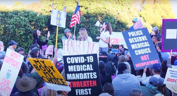 People hold various signs expressing their objection to COVID-19 vaccine mandates at a protest in San Francisco. (Nancy Han/NTD Television)