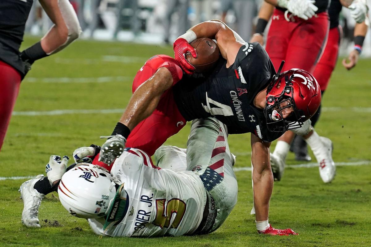Cincinnati running back Ethan Wright (4) runs over South Florida linebacker Antonio Grier Jr., for a touchdown during the second half of an NCAA college football game in Tampa, Fla., on Nov. 12, 2021. (Chris O'Meara/AP Photo)
