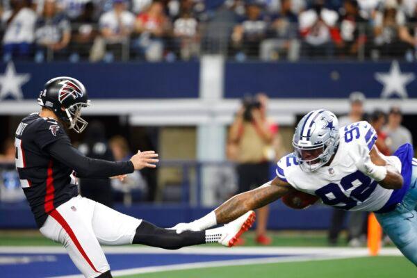 Atlanta Falcons punter Dustin Colquitt has his punt blocked by Dallas Cowboys defensive end Dorance Armstrong (92) in the first half of an NFL football game in Arlington, Tex., on Nov. 14, 2021. (Ron Jenkins/AP Photo)