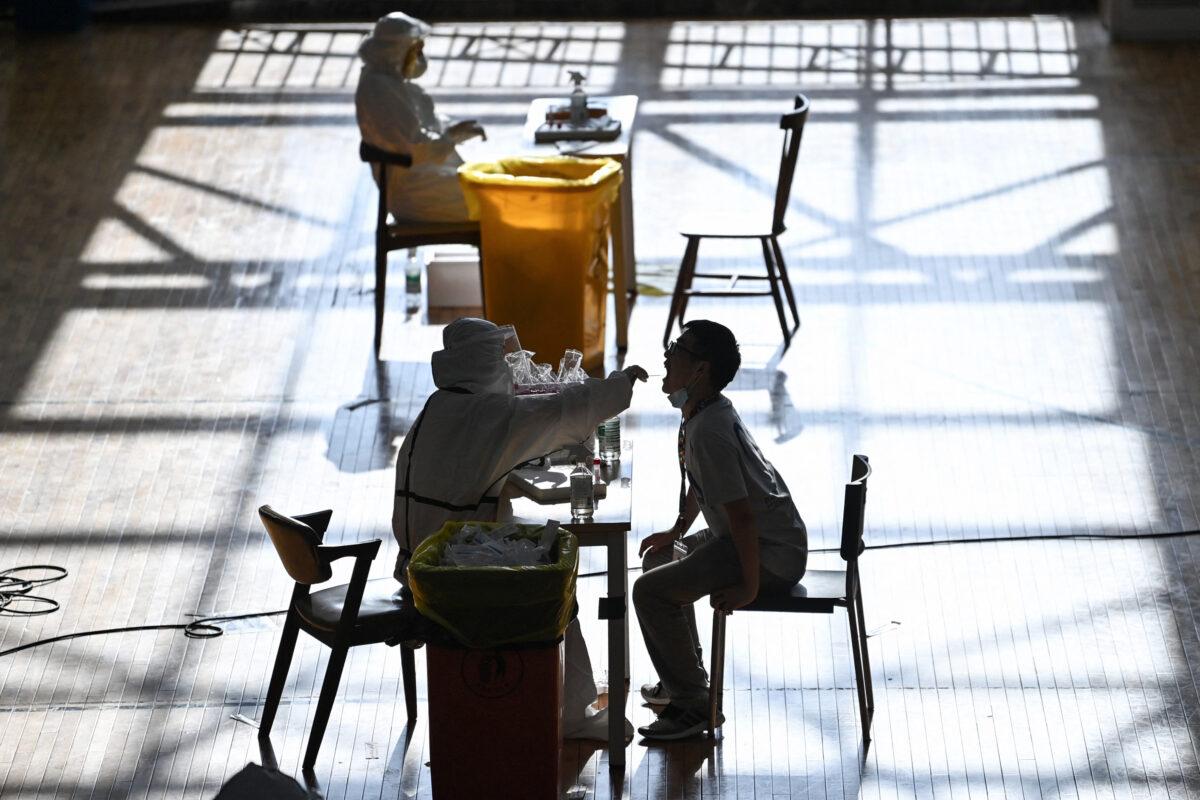 A staff member is being given a nucleic acid test for COVID-19 at the gym of a company in Wuhan in China's Hubei Province, on Aug. 5, 2021. (STR/AFP via Getty Images)