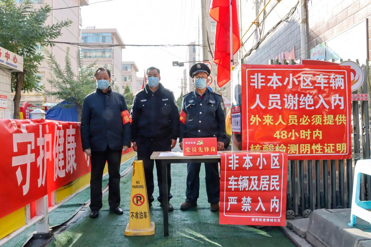 Security staff stand guard at the entrance of a residential area following COVID-19 cases in Zhangye in China's Gansu Province, on Oct. 23, 2021. (STR/AFP via Getty Images)