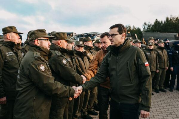 In this handout image provided by the Polish Ministry Of Defense, Polish Prime Minister Mateusz Morawiecki meets border army units at the Belarusian-Polish border as illegal immigrants gather on the border in Kuznica, Poland, on Nov. 9, 2021. ( Polish Ministry Of Defense via Getty Images)