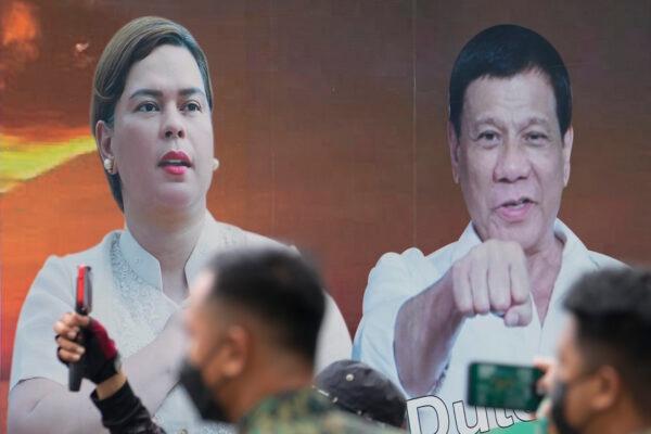 A vehicle bearing photos of Philippine President Rodrigo Duterte (R) and his daughter Davao City Mayor Sara Duterte passes by outside the Commission on Elections in Manila, Philippines, on Nov. 15, 2021. (Aaron Favila/AP Photo)