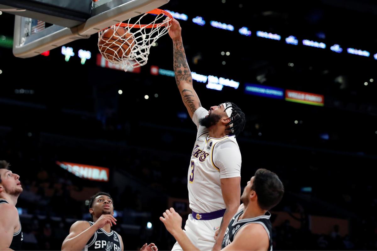 Los Angeles Lakers forward Anthony Davis, second from right, dunks against San Antonio Spurs forward Drew Eubanks, (L), guard Devin Vassell, second from left, and forward Doug McDermott, (R), during the first half of an NBA basketball game in Los Angeles, on Nov. 14, 2021. (Alex Gallardo/AP Photo)