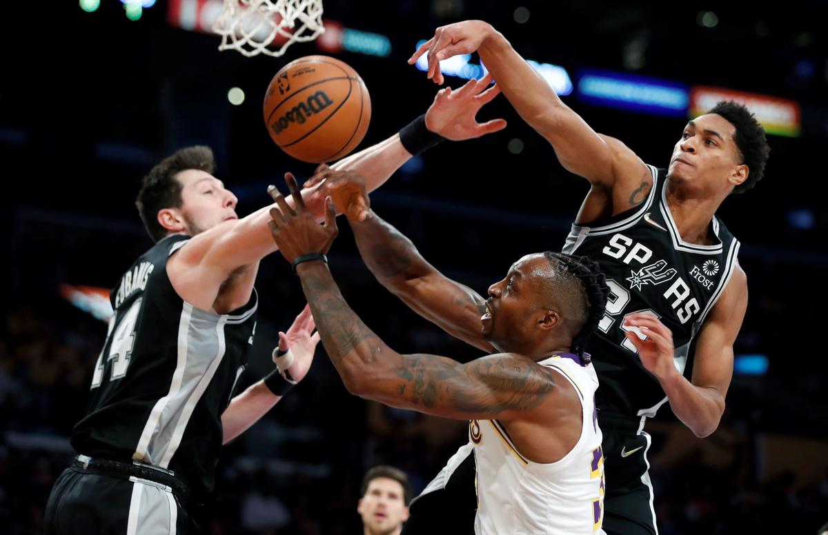 Los Angeles Lakers center Dwight Howard, (C), battles San Antonio Spurs forward Drew Eubanks, (L), and guard Devin Vassell for the ball during the first half of an NBA basketball game in Los Angeles, on Nov. 14, 2021, . (Alex Gallardo/AP Photo)