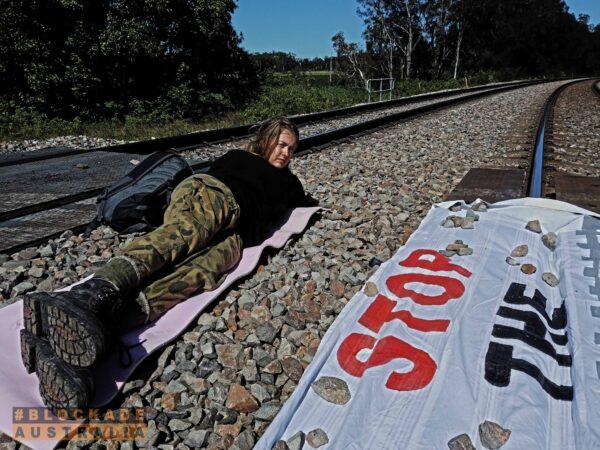 Blockade Australia activist locked to a pipe in the side of a rail line near Port of Newcastle, Australia, on Nov. 15, 2021. (Blockade Australia)